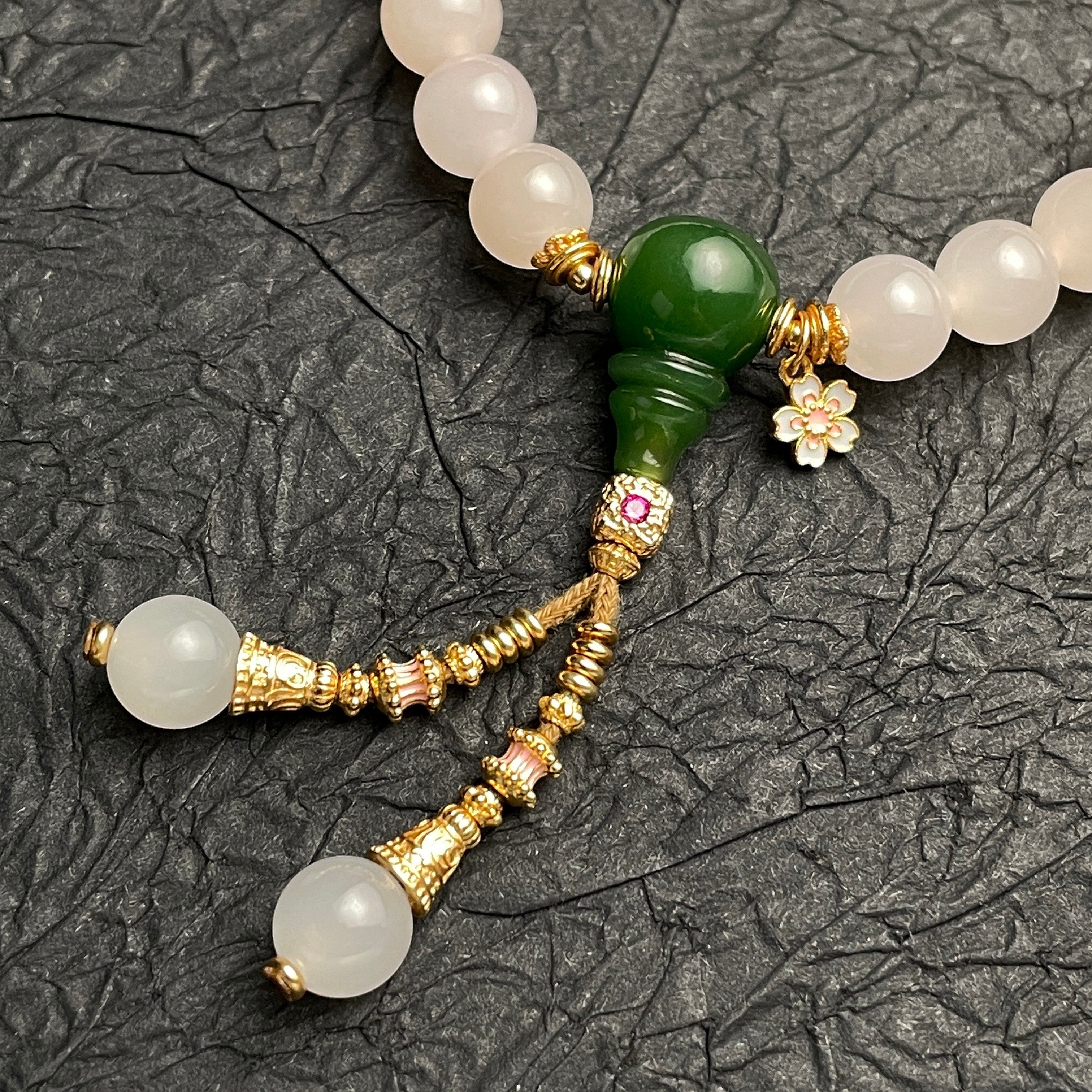 Sylvia Jewelry 粉色水晶和绿色玉石串珠手链，带有金色流苏和花朵吊坠。