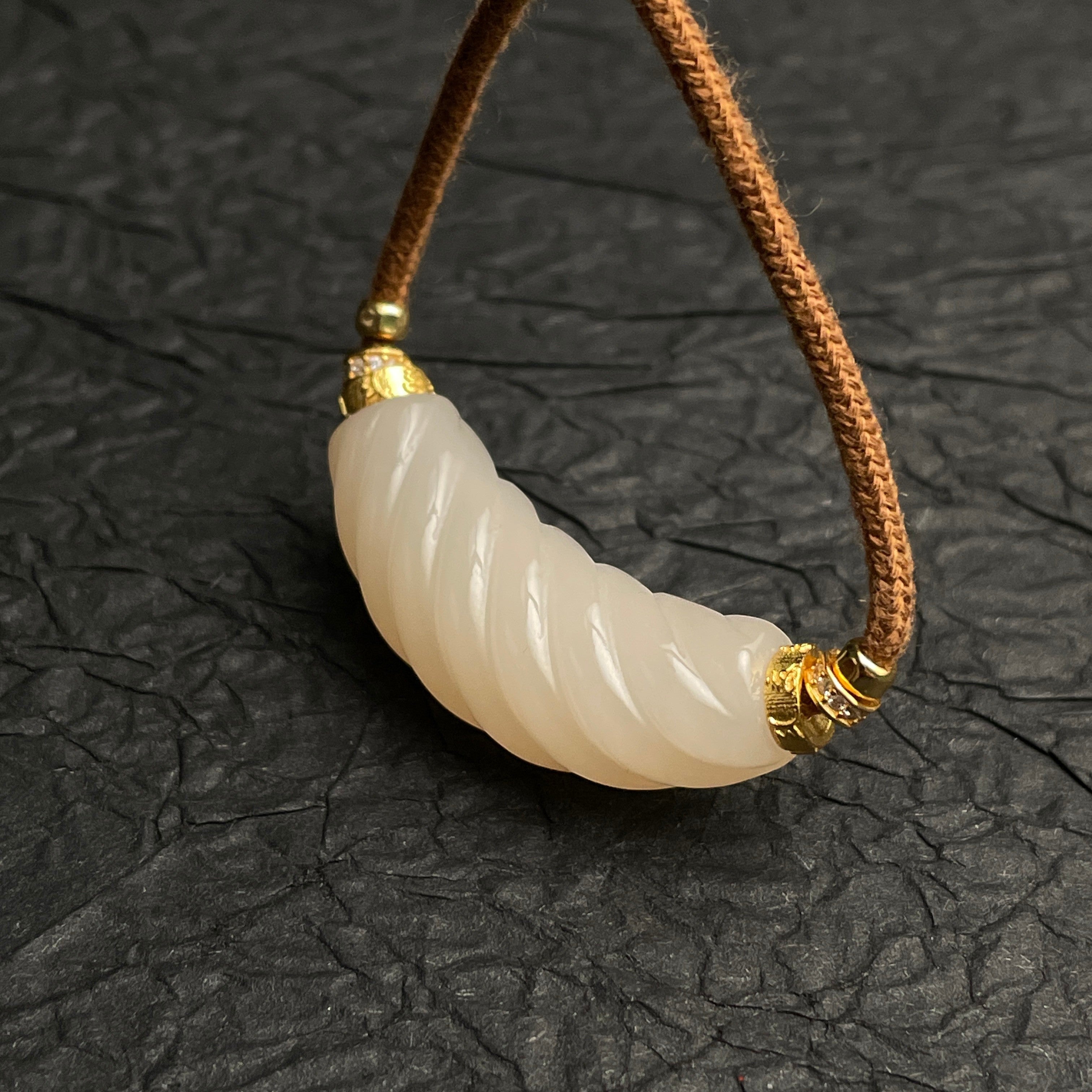 Sylvia Jewelry 扭转粉色和田玉吊坠，金色镶嵌，搭配棕色绳链，优雅浪漫。