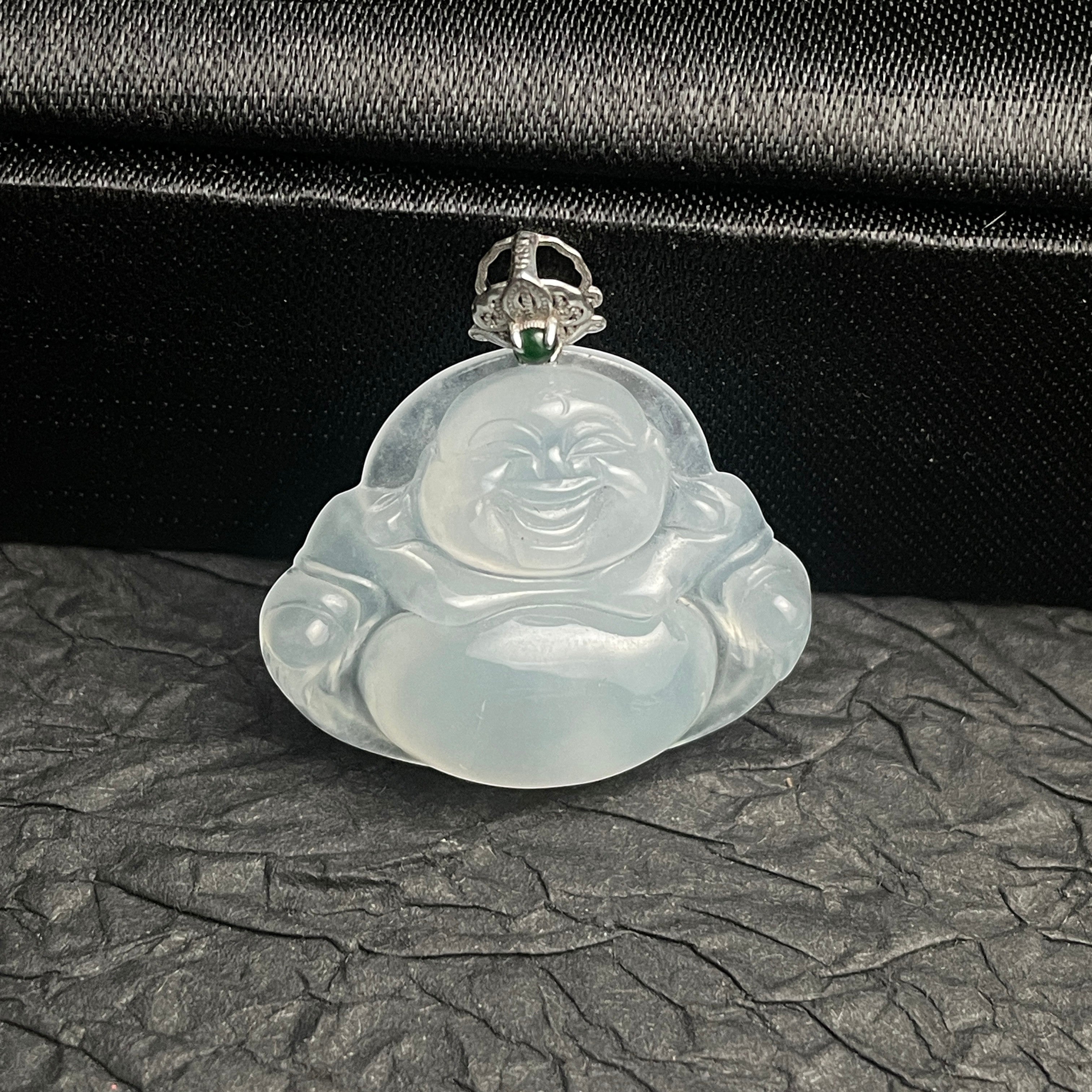 Sylvia Jewelry translucent white jadeite laughing Buddha pendant with a decorative silver bail on a black background.
