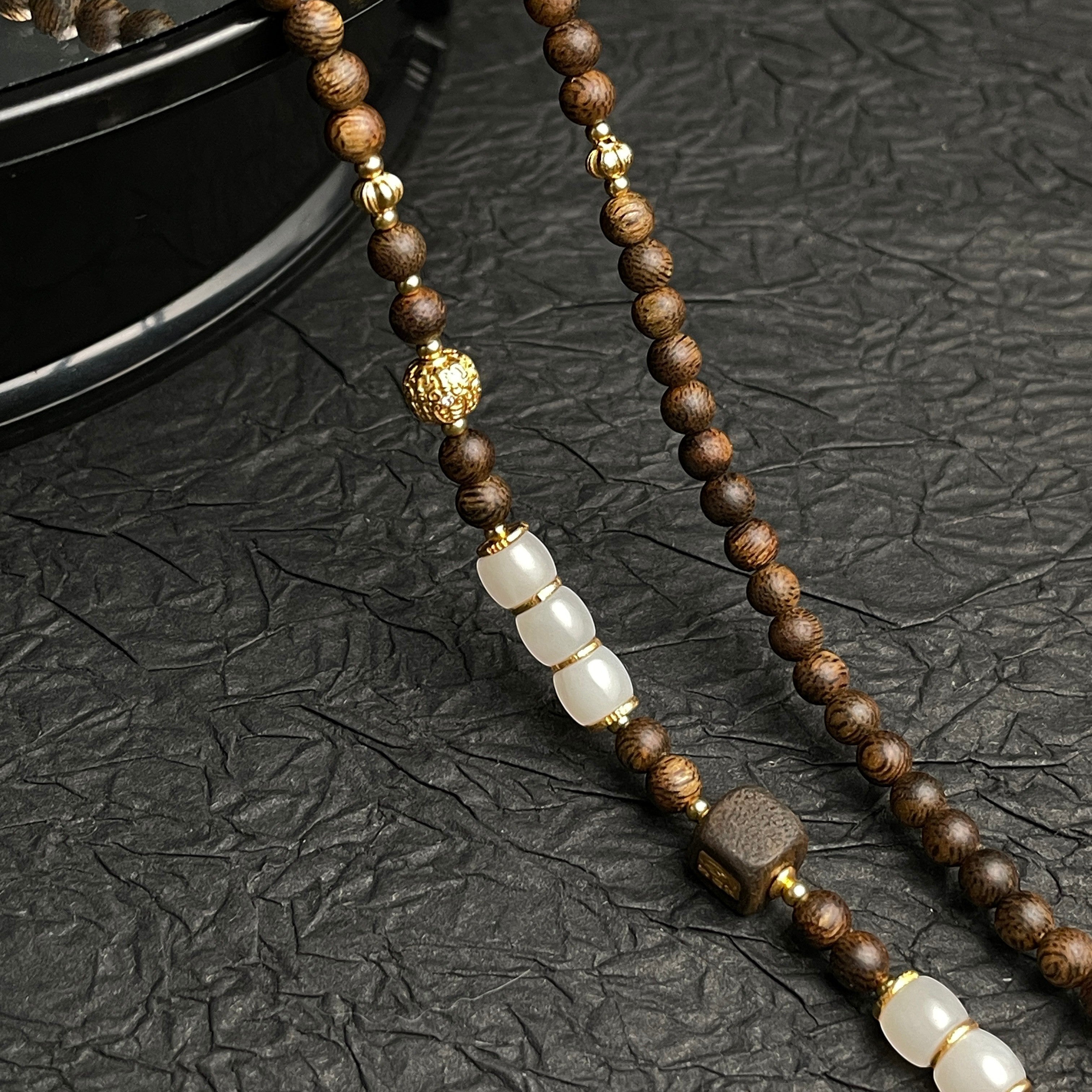 Sylvia Jewelry beaded necklace featuring dark brown wood beads, white jade accents, and gold-tone metal spacers.