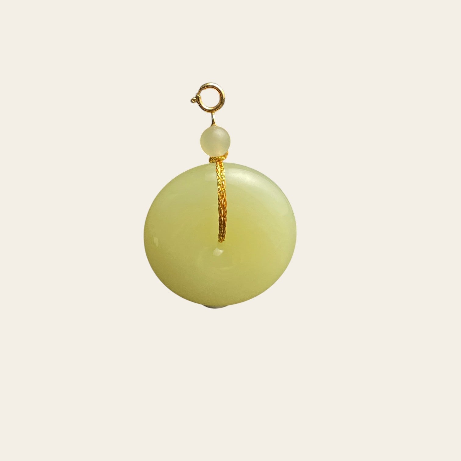 Sylvia Jewelry pale yellow Hetian jade Ping An Kou pendant with gold-plated silver hardware and cord-wrap detail.