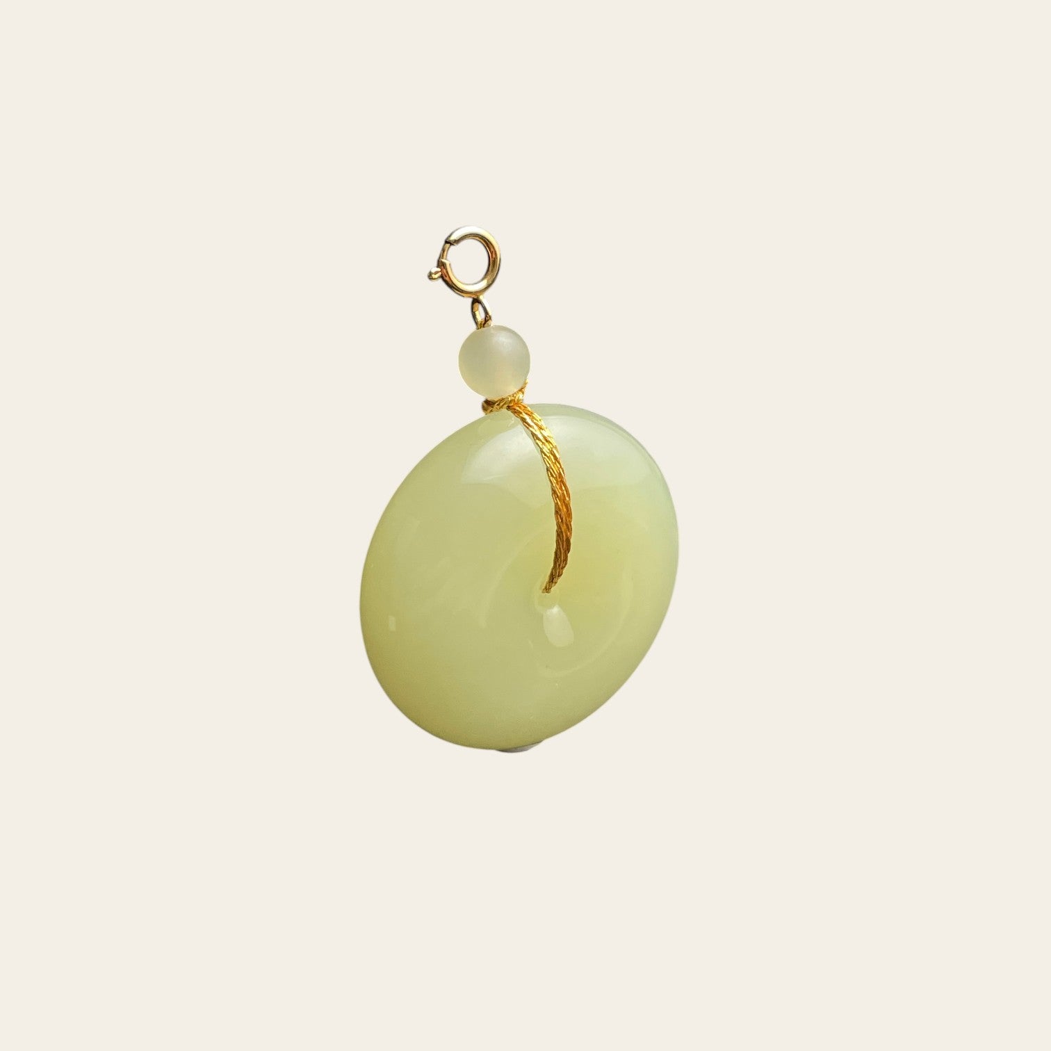 Sylvia Jewelry pale yellow Hetian jade Ping An Kou pendant with gold-plated silver hardware and cord accent.