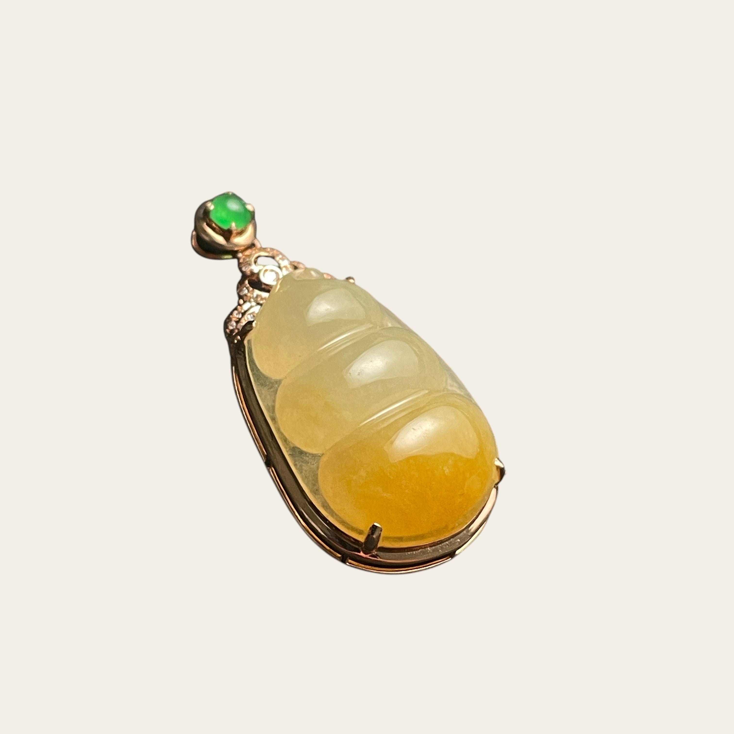 Sylvia Jewelry ice-species yellow jadeite fortune bean pendant with 18k gold, diamonds, and a green jade cabochon.