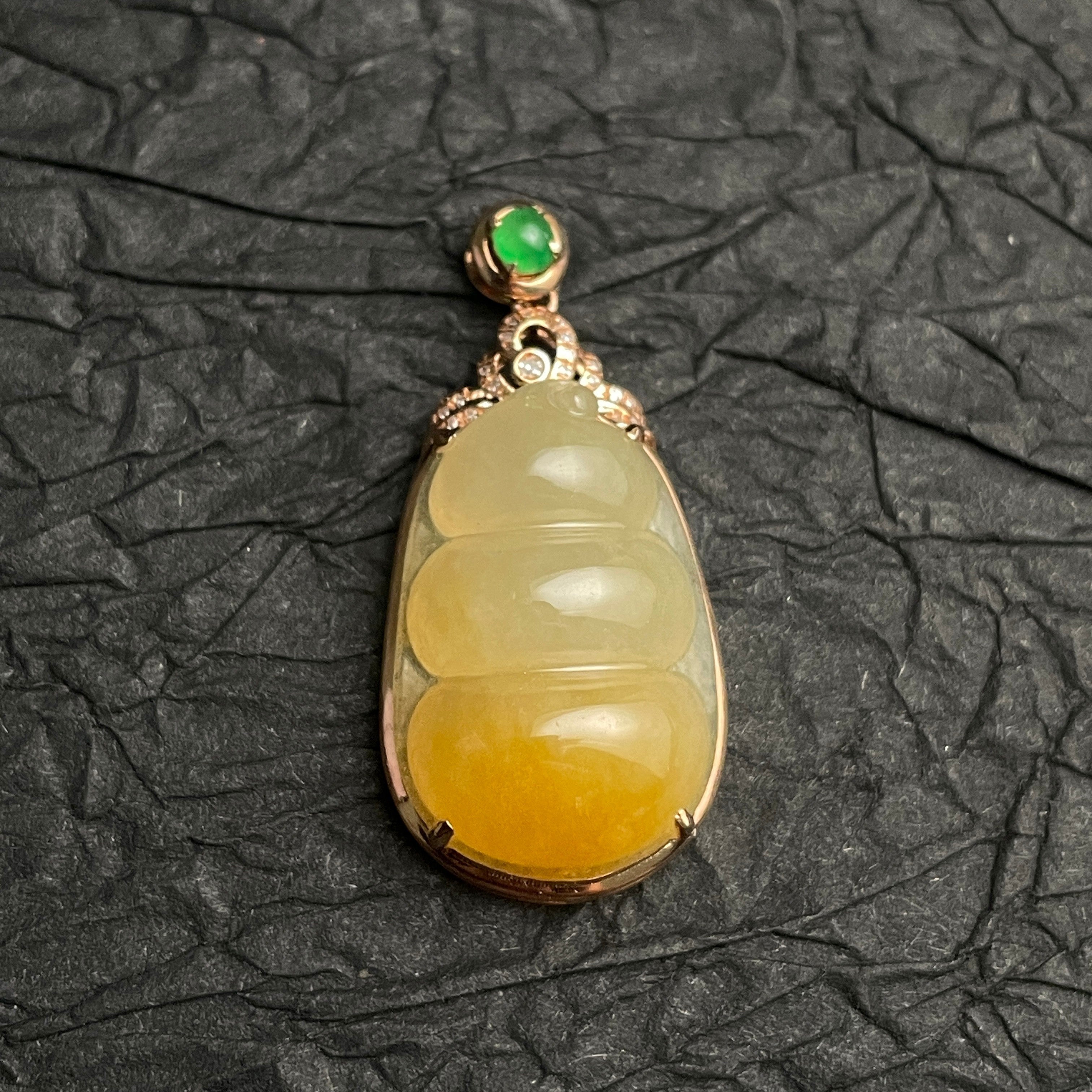 Sylvia Jewelry ice-species yellow jadeite fortune bean pendant with 18k gold, diamonds, and a green jade cabochon.