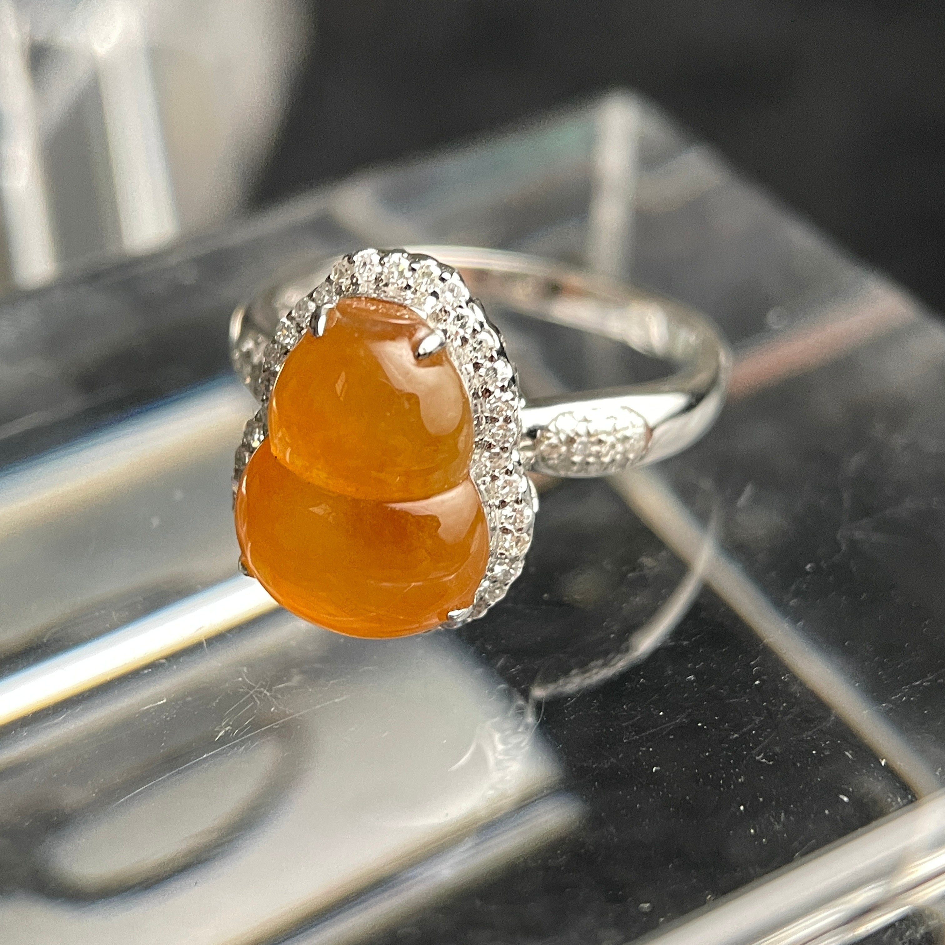Sylvia Jewelry yellow jadeite gourd ring with diamond halo in 18K white gold on a clear display stand.