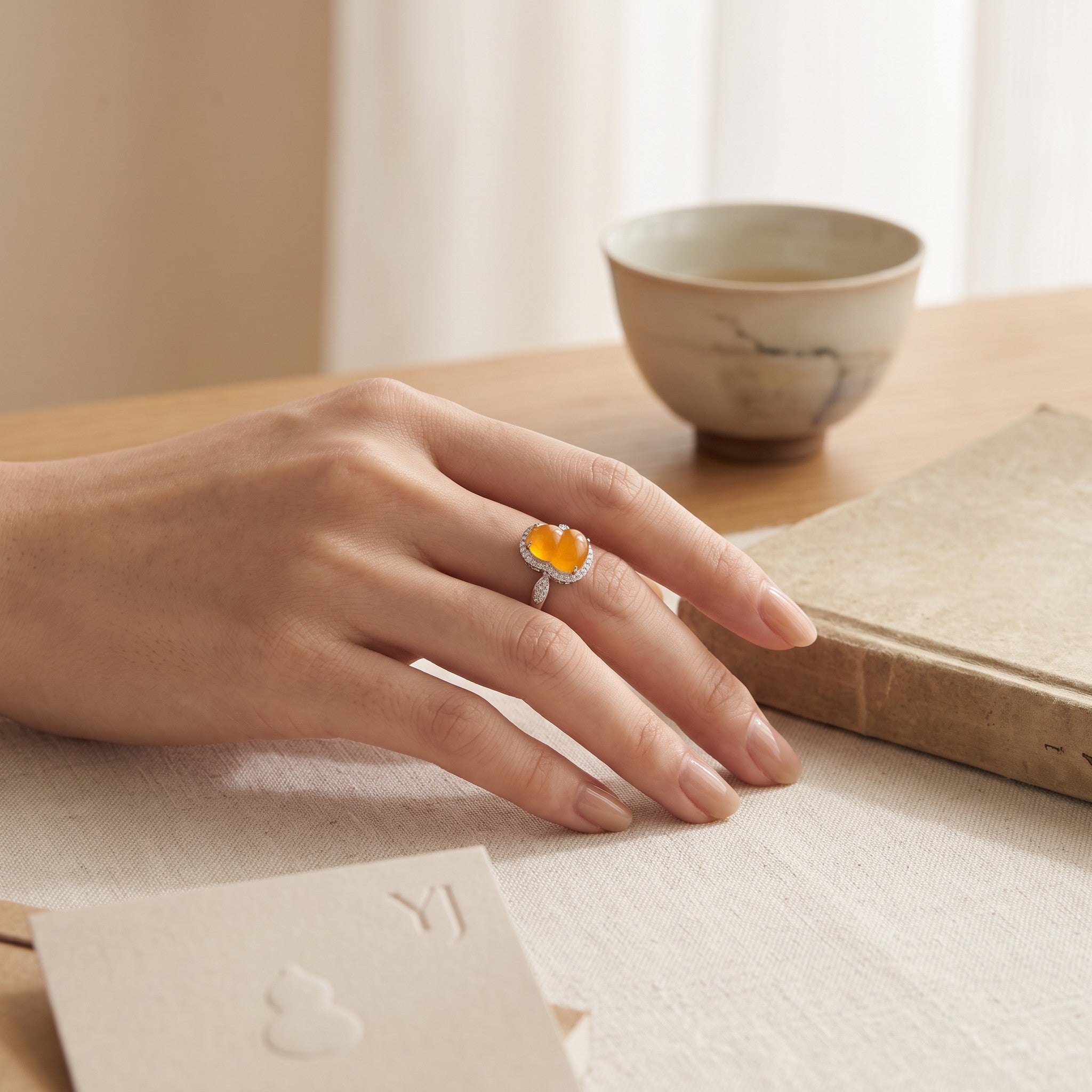 Sylvia Jewelry yellow jadeite gourd ring with diamond halo set in 18K white gold worn on a hand