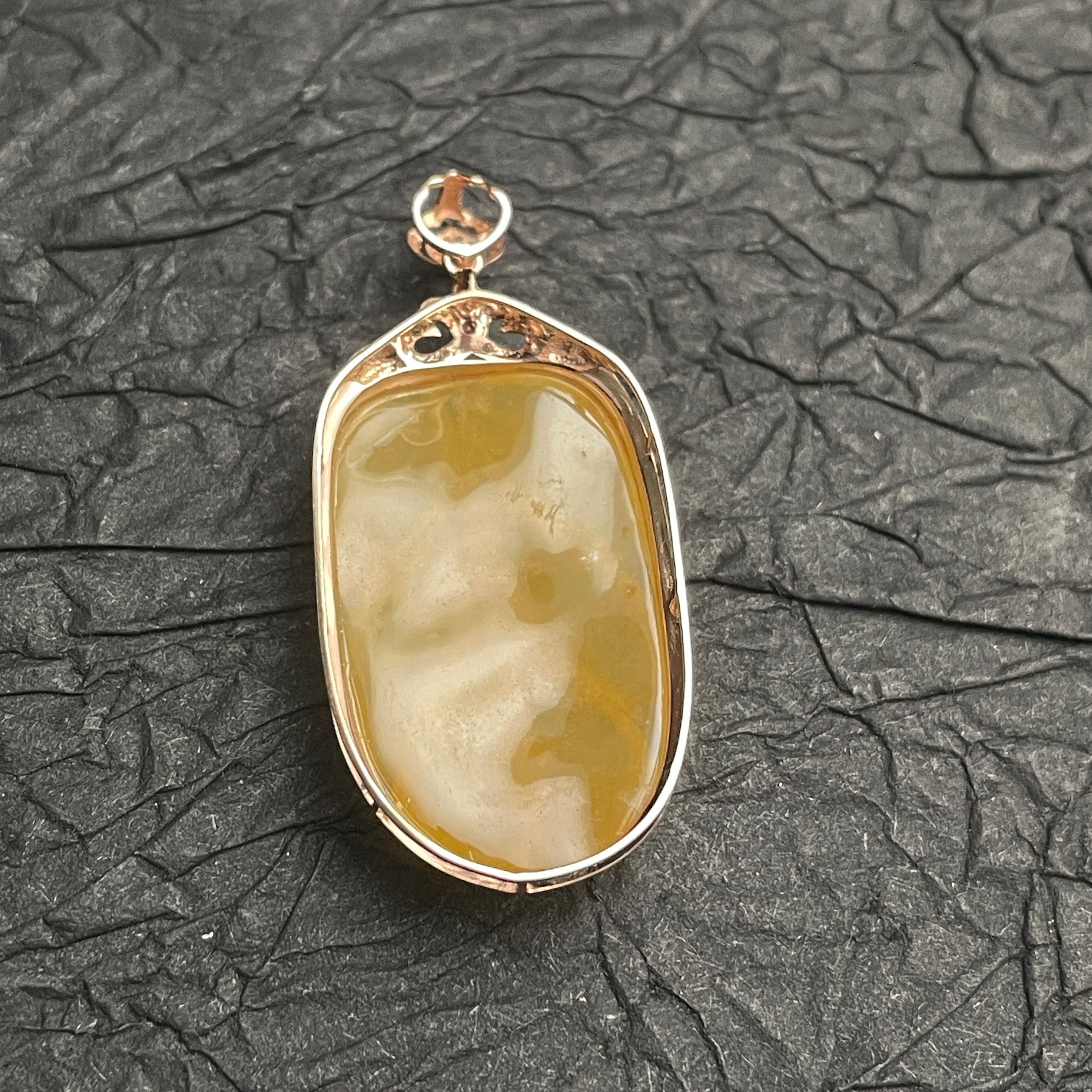 Sylvia Jewelry yellow jadeite leaf pendant in 18k rose gold with diamond accents on a textured black background.