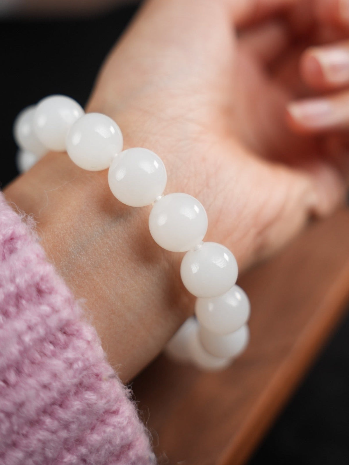 Close-up of white Hetian nephrite jade bracelet worn on wrist, B12609024891